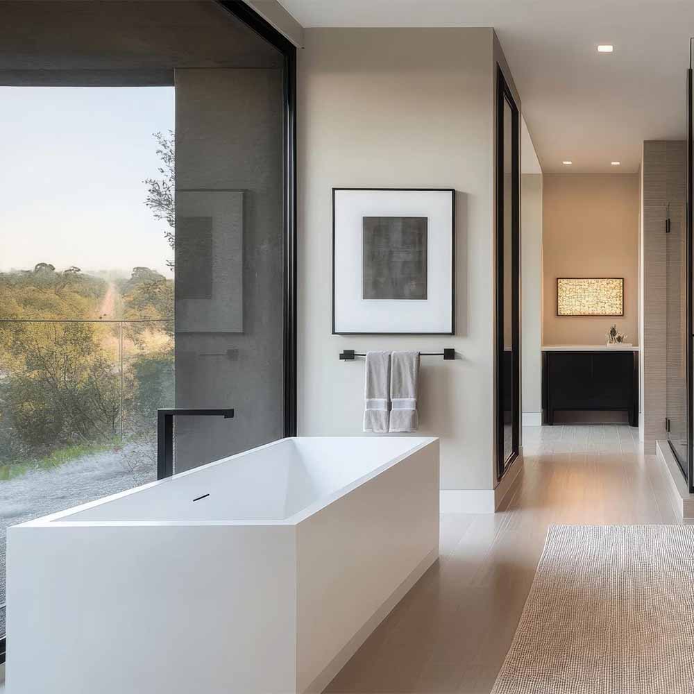 A modern bathroom with a square bath and window in shot.